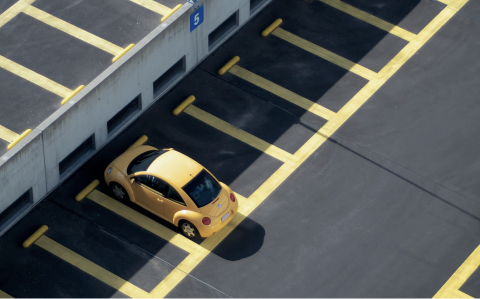 yellow car parked in empty parking lot