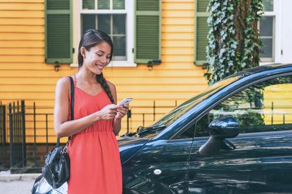 A woman smiles while looking at her phone