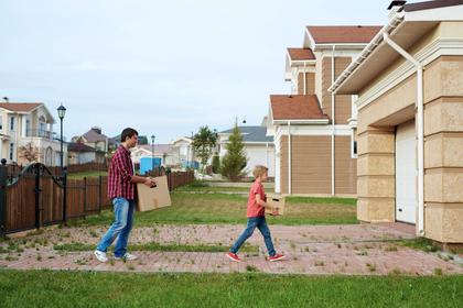 Man and boy moving boxes into a house