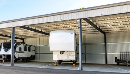 A camper trailer being stored underneath an awning